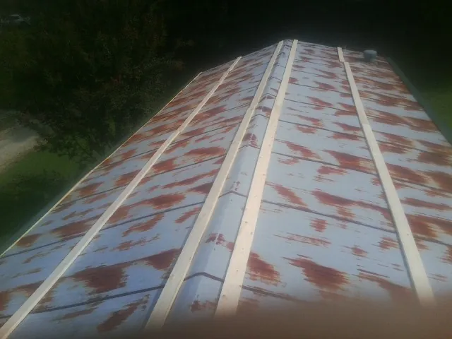 Rusted metal roof panels with new wood purlins before replacement — Storm Damage Roof Repair in Central Village by Roofing Brothers
