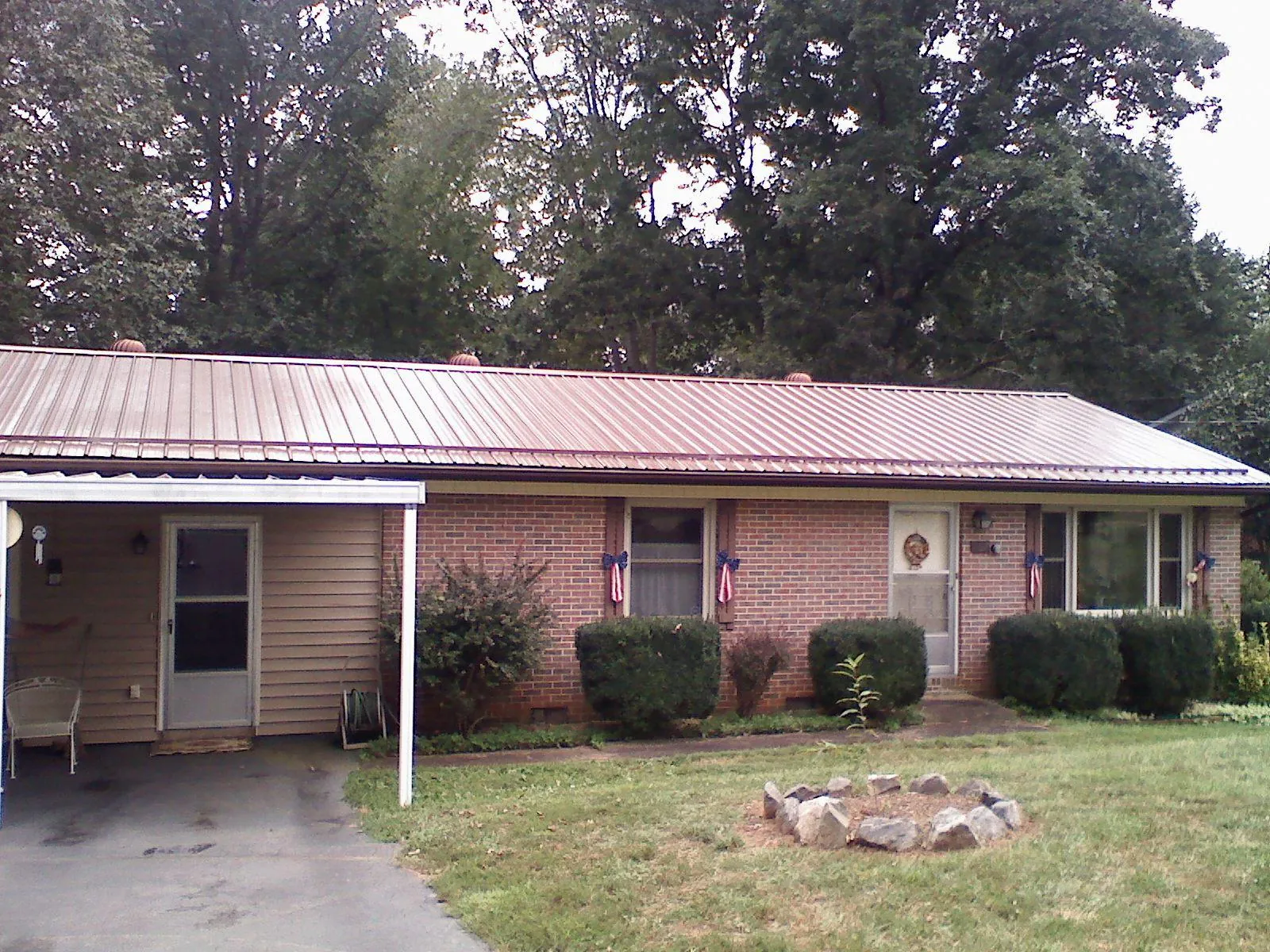 Bronze metal roof and carport on a brick ranch home — Roof Repair work by our crew in Central Village
